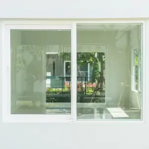 Janela de correr de duas folhas branca tipo Blindex, vista do interior com jardim ao fundo